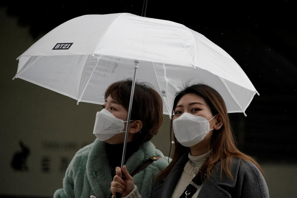 Passengers wearing masks to prevent contacting the coronavirus walk outside Seoul Railway Station in Seoul, South Korea, February 25, 2020.   REUTERS/Kim Hong-Ji