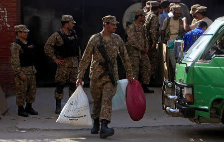 A soldier carries supplies to be delivered to a polling station from the election commission office in Lahore, Pakistan September 16, 2017. REUTERS/Mohsin Raza