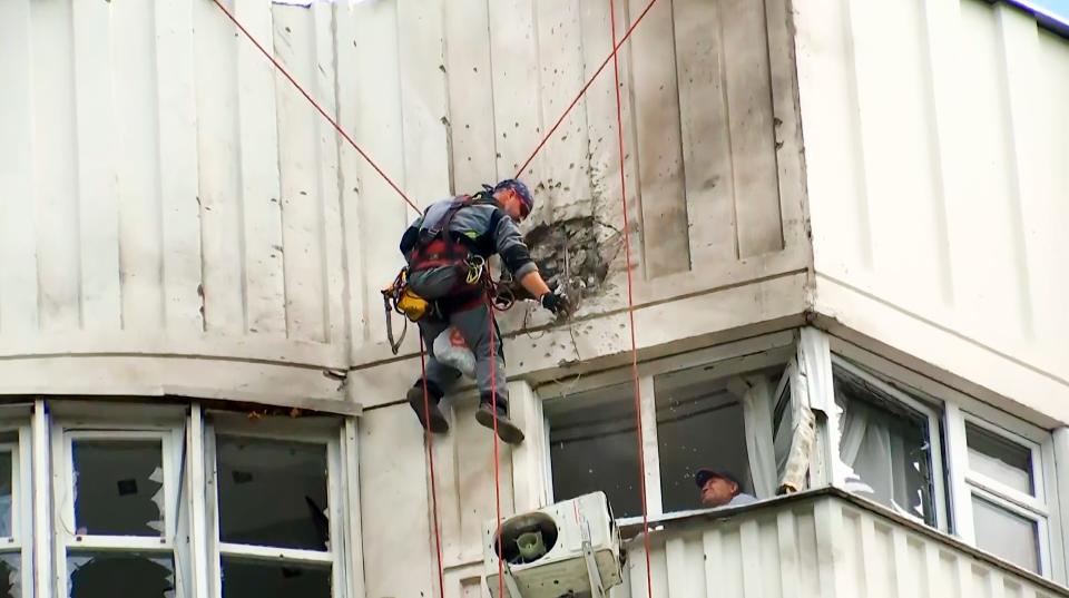 In this image taken from video, investigators inspect a building after a Ukraine drone damaged an apartment building in Moscow on May 30, 2023.