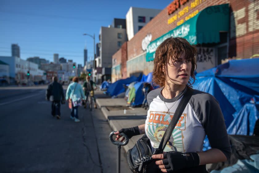 Los Angeles, CA - February 05: **NOTE: This image is specifically to be used for a public health story by Emily Alpert Reyes. Soma Snakeoil, Co-Founder and Executive Director of The Sidewalk Project picks up syringes off the sidewalk next to a tent on Sunday, Feb. 5, 2023, in Los Angeles, CA. She is handing out socks, Narcan, lunches, towels, tampons, condoms, clothing, and harm reduction items. Sometimes they come across people overdosing on the street and they administer Narcan.(Francine Orr / Los Angeles Times)