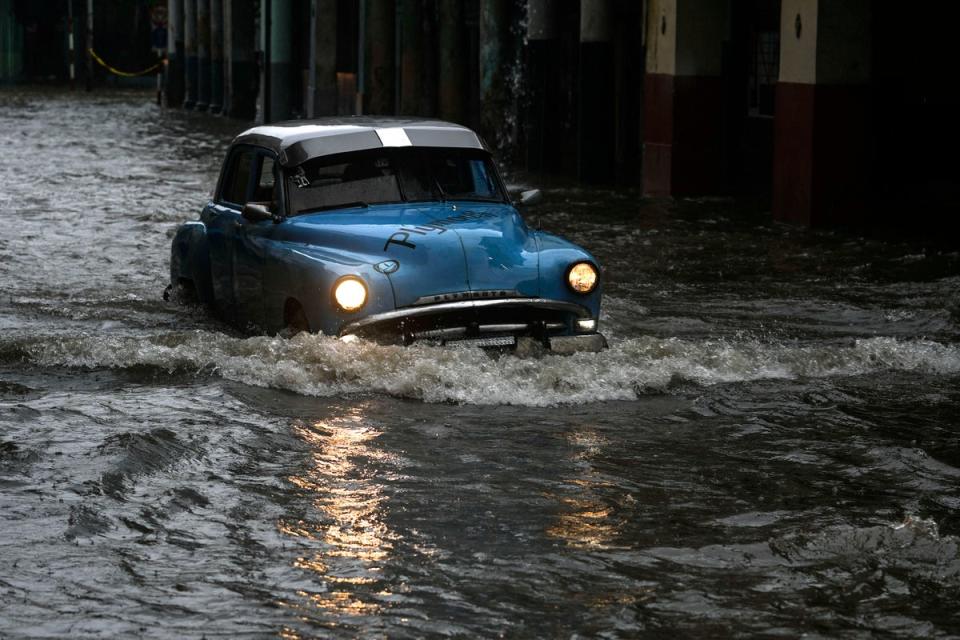 A Cuban driving a classic American car meets their match in Havana, Cuba on 3 June 2022 (AP Photo/Ramon Espinosa)