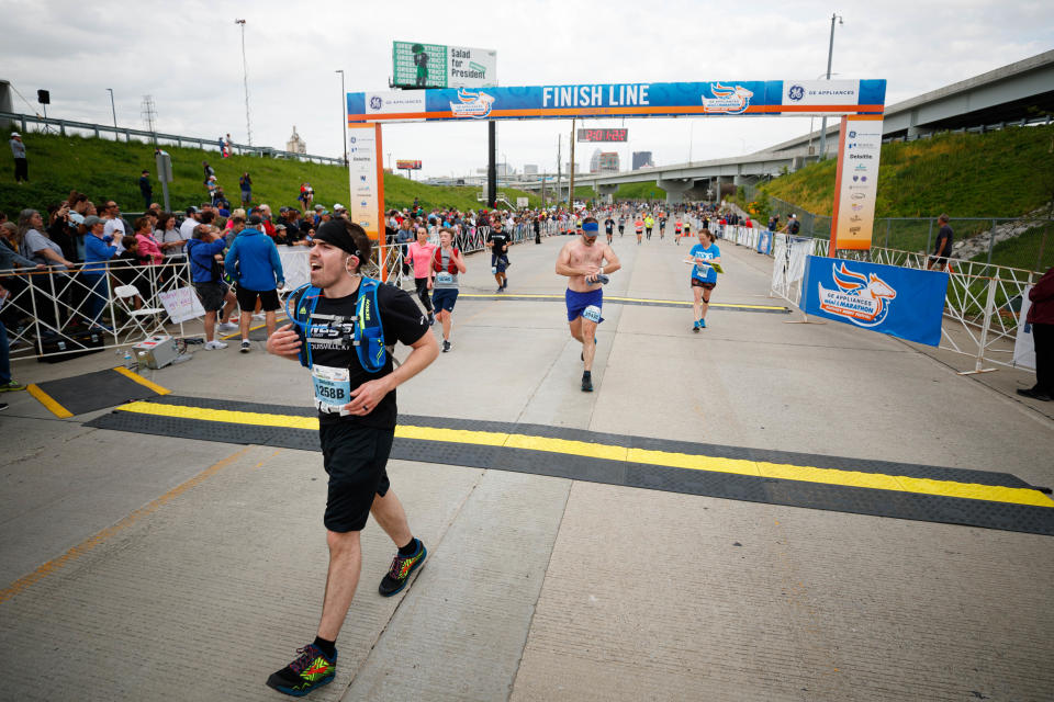 Runners cross the finish line during the 2022 Kentucky Derby Festival mini Marathon and full marathon on Saturday, April 30, 2022, at Lynn Family Stadium in Louisville, Kentucky.