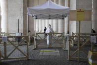 Medical personnel wait for visitors to check their temperatures to prevent the spread of COVID-19 in a control point set under the colonnade designed by 16th century Italian sculptor and architect Gian Lorenzo Bernini, St. Peter's square at the Vatican in the day of the reopening of St. Peter's Basilica, Monday, May 18, 2020. Italy is slowly lifting sanitary restrictions after a two-month coronavirus lockdown. (AP Photo/Alessandra Tarantino)