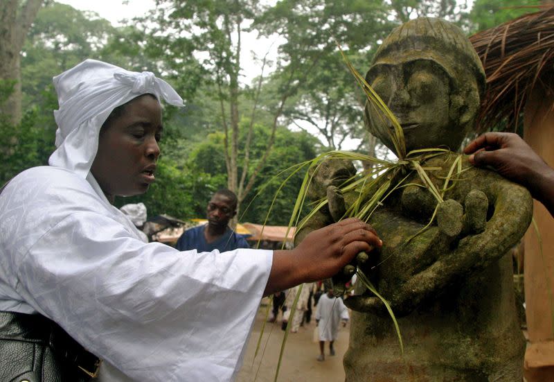 FILE PHOTO: An Osun goddess worshipper prays to an idol at the Osun sacred Grove in Osogbo, southwestern Nigeria