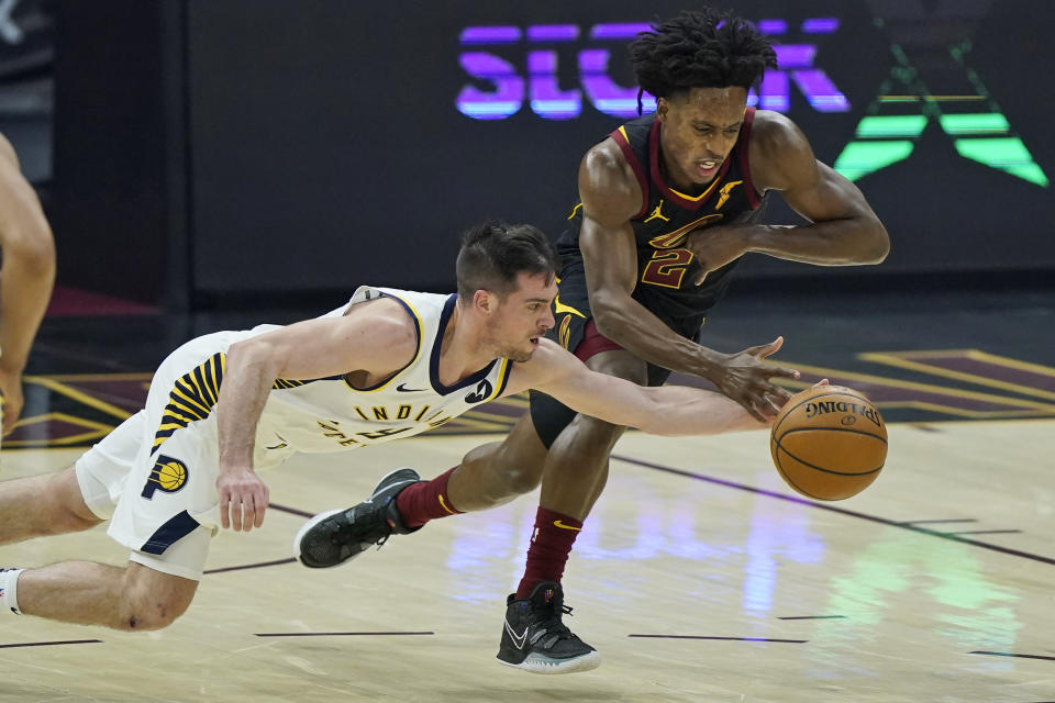 Indiana Pacers' T.J. McConnell, left, and Cleveland Cavaliers' Collin Sexton reach for the ball during the first half of an NBA basketball game Wednesday, March 3, 2021, in Cleveland. (AP Photo/Tony Dejak)