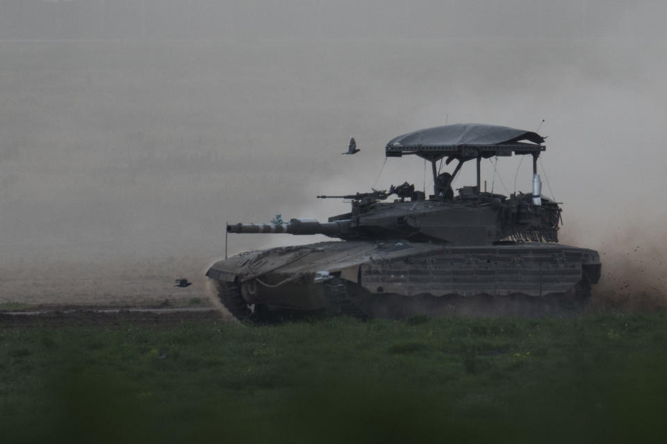 Israeli soldier moves on the top of a tank near the Israeli-Gaza border, as seen from southern Israel, Thursday, Feb. 15, 2024. (AP Photo/Leo Correa)