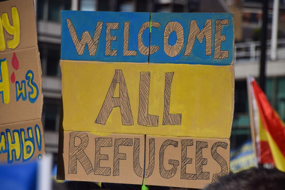 LONDON, UNITED KINGDOM - 2022/03/26: 'Welcome All Refugees' placard with the colours of the Ukraine flag is seen during the 'London Stands With Ukraine' march. Thousands of people marched from Park Lane to Trafalgar Square in solidarity with Ukraine as Russia continues its attack. (Photo by Vuk Valcic/SOPA Images/LightRocket via Getty Images)