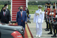 In this photo released by Indonesian Presidential Palace, Japanese Prime Minister Yoshihide Suga, center, walks to his car upon arrival at Halim Perdanakusuma Airport in Jakarta, Indonesia, Tuesday, Oct. 20, 2020. Suga arrived in Indonesia on the second leg of his first overseas trip as premier to underscore his government’s aims of countering China in the region. (Indonesian Presidential Palace via AP)