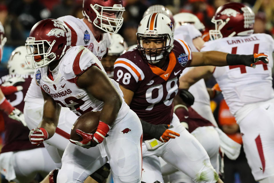 Dec 29, 2016; Charlotte, NC, USA; Arkansas Razorbacks running back Rawleigh Williams III (22) runs back past Virginia Tech Hokies defensive tackle Ricky Walker (98) during the Belk Bowl at Bank of America Stadium in Charlotte, NC. The Hokies win the Belk Bowl 35-24 over the Razorbacks. Mandatory Credit: Jim Dedmon-USA TODAY Sports