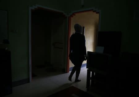 A transgender person walks at her office in Banda Aceh, December 25, 2014. REUTERS/Beawiharta