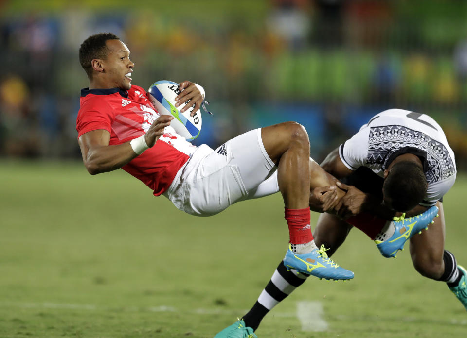FILE - In this Aug. 11, 2016, file photo, Britain's Dan Norton, left, is tackled by Fiji's Osea Kolinisau, during the men's rugby sevens gold medal match at the Summer Olympics in Rio de Janeiro, Brazil. It was rugby in fast forward and it generated millions of new fans across the world. Rugby sevens made its Olympic debut in Rio de Janeiro in 2016 bringing all the usual hard-hitting tackles, collisions and swerving runs but leaving out the slow-mo elements of the traditional 15-a-side game. (AP Photo/Themba Hadebe, File)
