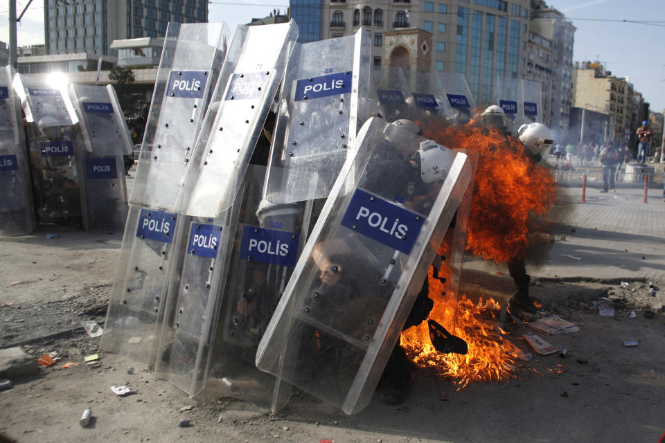 A petrol bomb explodes in front of riot policemen during clashes in Taksim Square in Istanbul, Turkey, Tuesday, June 11, 2013. Hundreds of police in riot gear forced through barricades in Istanbul's central Taksim Square early Tuesday, pushing many of the protesters who had occupied the square for more than a week into a nearby park. (AP Photo/Kostas Tsironis)