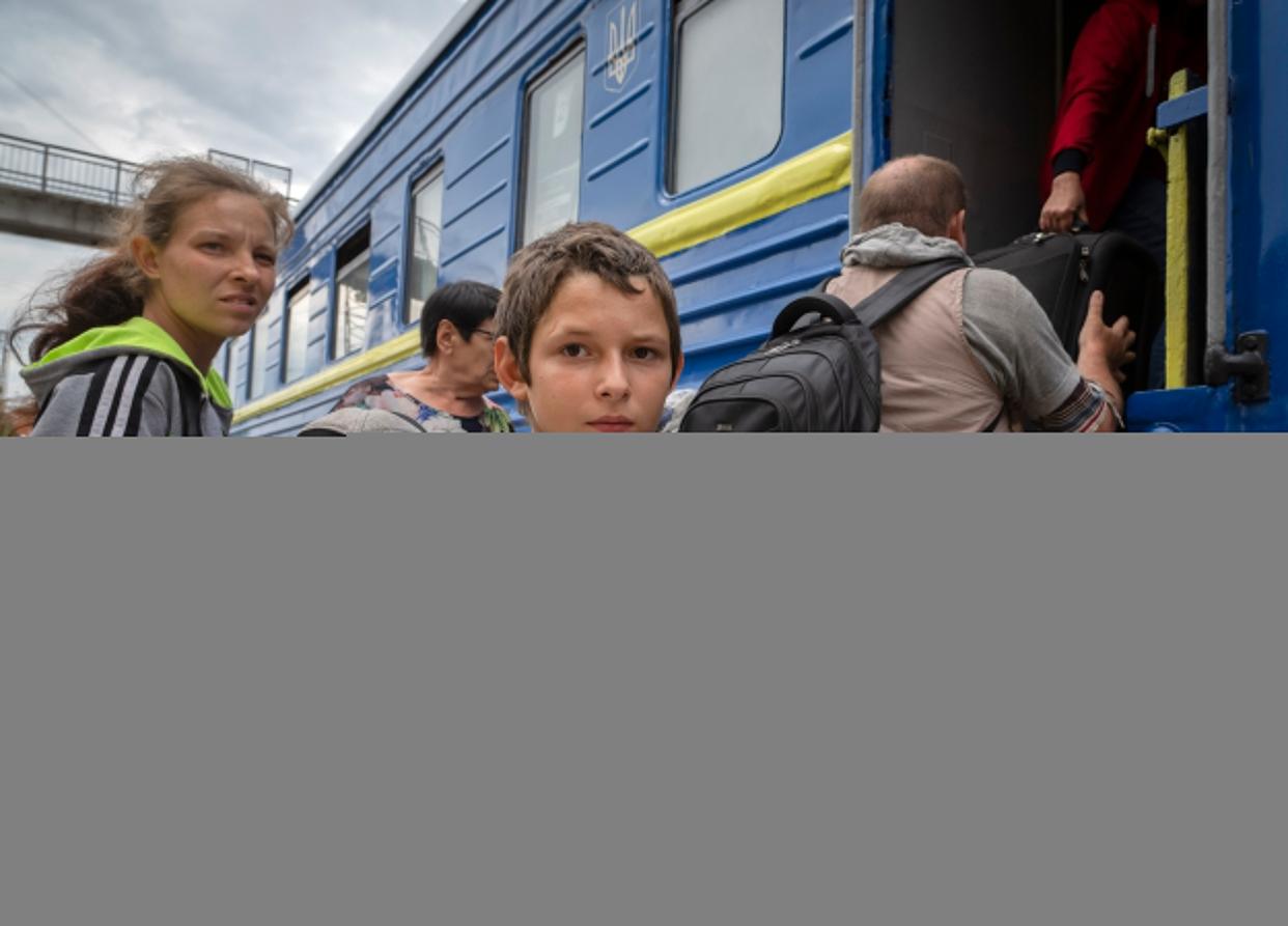 A boy holds his pet dog as his family evacuated from the war-hit area gets on an evacuation train in Pokrovsk, eastern Ukraine, on Saturday.