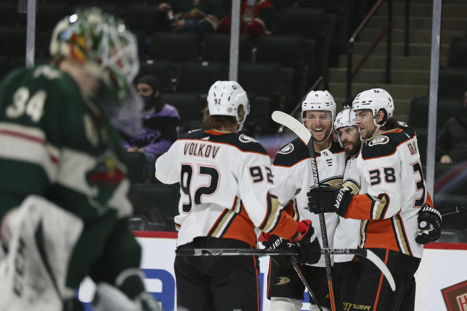 Anaheim Ducks' Adam Henrique (14) is surrounded by teammates after scoring a goal against the Minnesota Wild during the second period of an NHL hockey game Friday, May 7, 2021, in St. Paul, Minn. (AP Photo/Stacy Bengs)