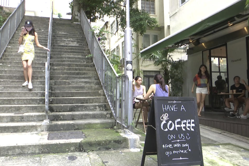 In this image made from a video, a woman walks down steps near Hong Kong's first CBD cafe, Sept. 13, 2020. Hong Kong banned cannibidiol, also known as CBD, as a "dangerous drug" and imposed harsh penalties for possession on Wednesday, Feb. 1, 2023, forcing fledging businesses to shut down and revamp. (AP Photo/Alice Fung)