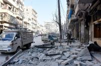 A member of Syrian pro-government forces walks on a street in al-Maadi district of eastern Aleppo on December 11, 2016 after they retook a large part of it from rebel fighters