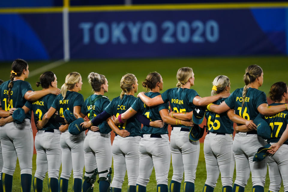 Members of team Australia stand ahead a softball game with Mexico at the 2020 Summer Olympics, Monday, July 26, 2021, in Yokohama, Japan. (AP Photo/Matt Slocum)