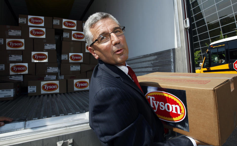 Donnie Smith, CEO and president of Tyson Foods Inc., removes a box of frozen chicken drumstick stands, Thursday, June 21, 2012, in Jackson, Miss. Smith was participating in a new program with the National Urban League that is designed to reduce hunger in Mississippi, one of the poorest states in the nation. (AP Photo/Rogelio V. Solis)