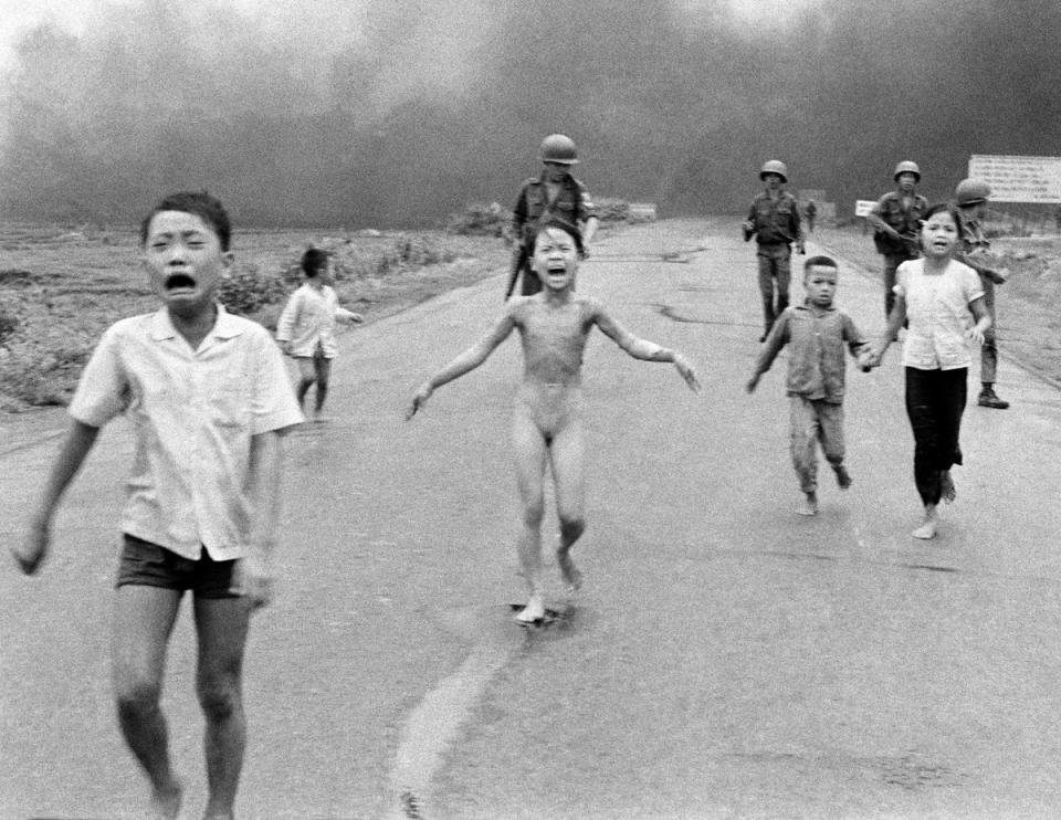 South Vietnamese forces follow terrified children, including 9-year-old Kim Phuc, center, as they run down Route 1 near Trang Bang after an aerial napalm attack on suspected Viet Cong hiding places on 8 June 1972 (AP)