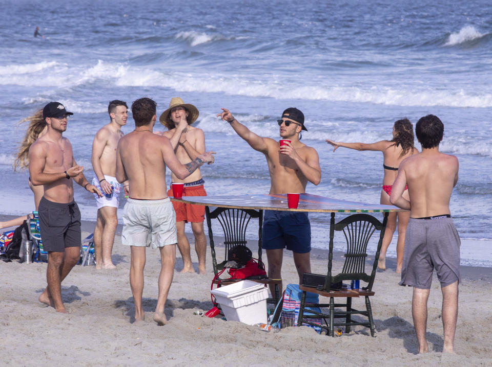 Despite warnings from government officials take caution and self distance because of coronavirus, many college students, some from Coastal Carolina University, hang out on the beach at 65th Avenue North in Myrtle Beach, S.C. on March 19, 2020. | Jason Lee—The Sun News/AP