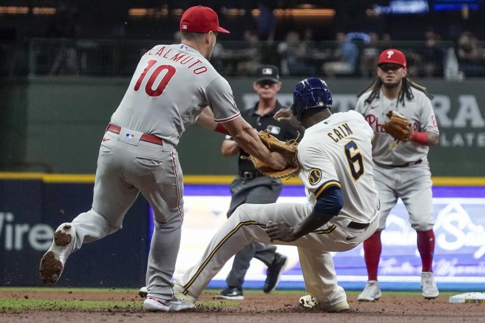 Philadelphia Phillies' J.T. Realmuto tags out Milwaukee Brewers' Lorenzo Cain after being caught in a rundown during the third inning of a baseball game Tuesday, Sept. 7, 2021, in Milwaukee. (AP Photo/Morry Gash)