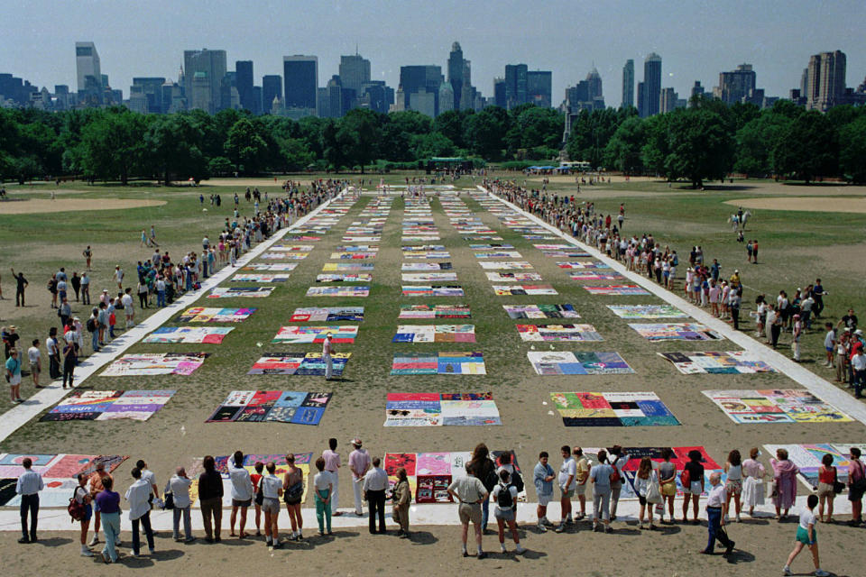 FILE - In this Saturday, June 25, 1988 file photo, people watch as almost 1,500 quilt panels bearing the names of New York area residents who have died of AIDS are unfolded on the Great Lawn in New York's Central Park. The panels, which are expected to be incorporated into the national Names Project AIDS Quilt, include 75 bearing the names of metropolitan area infants. (AP Photo/Wilbur Funches, File)