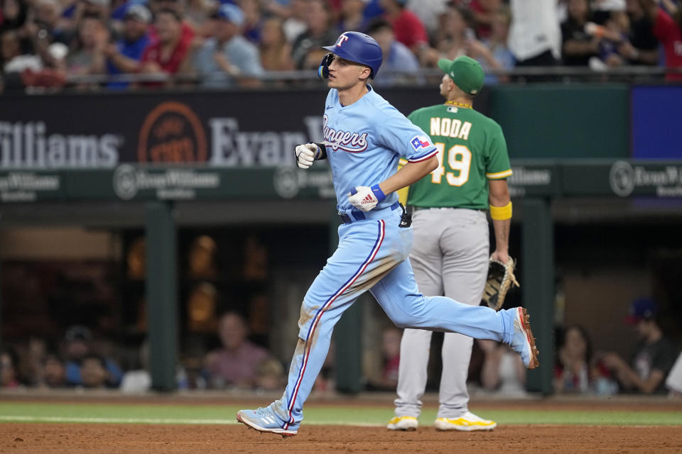 Texas Rangers' Corey Seager, front, rounds first past Oakland Athletics first baseman Ryan Noda (49) after hitting a solo home run in the sixth inning of a baseball game, Sunday, Sept. 10, 2023, in Arlington, Texas. (AP Photo/Tony Gutierrez)