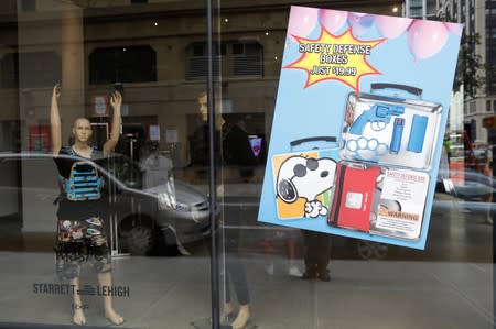 The art installation by artist WhIsBe titled "Back to School Shopping" to illustrate the dangers of gun violence in schools is seen through a window at a gallery in New York City