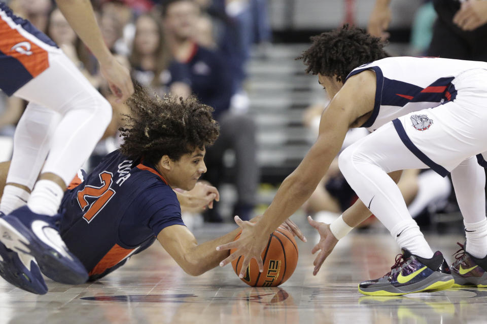 Pepperdine guard Nils Cooper (21) and Gonzaga guard Ryan Nembhard go after the ball during the first half of an NCAA college basketball game Thursday, Jan. 4, 2024, in Spokane, Wash. (AP Photo/Young Kwak)