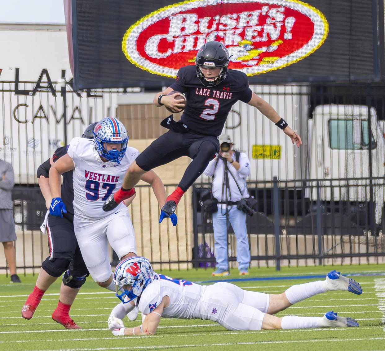 Lake Travis wide receiver Adrian Peradoza II hurdles Westlake free safety Payton Luther during their Class 6A Division I quarterfinal playoff game Saturday at the Pfield in Pflugerville. The Chaparrals won 21-14 to advance to the state semifinals.