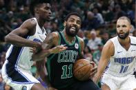 Boston Celtics' Kyrie Irving (11) drives for the basket between Orlando Magic's Evan Fournier (10) and Jonathan Isaac during the first half of an NBA basketball game in Boston, Sunday, April 7, 2019. (AP Photo/Michael Dwyer)