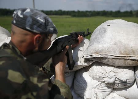 A pro-Russian separatist fighter from the so-called Battalion Vostok (East) looks out from a position at a check point on the outskirts of the eastern Ukrainian city of Donetsk, July 10, 2014. REUTERS/Maxim Zmeyev