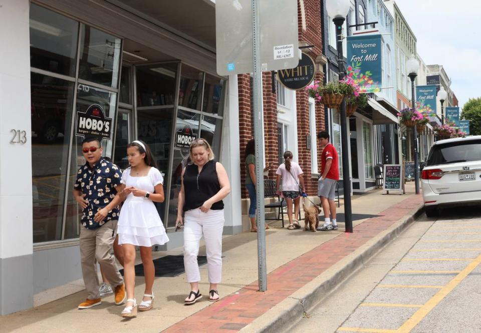 Groups of people walk down Main Street in downtown Fort Mill. Population increase in the town coincided with a rebirth of the downtown area with restaurants and retailers.