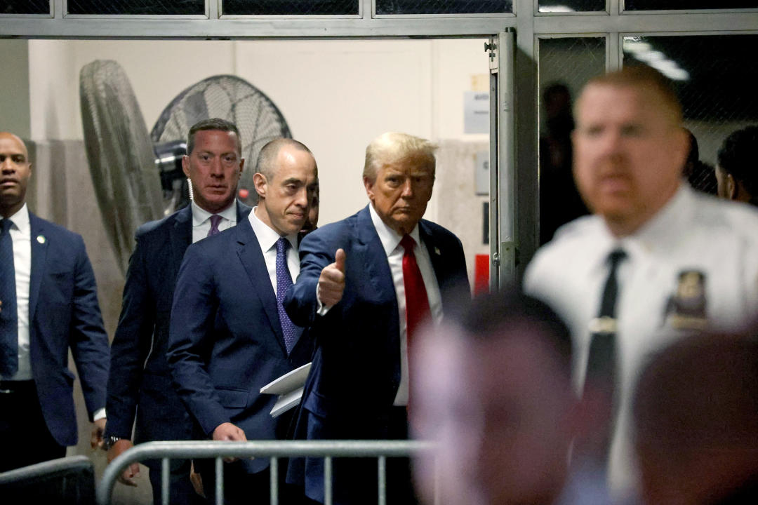 Donald Trump gives a thumbs-up as he walks past reporters during a break in Thursday's proceedings.