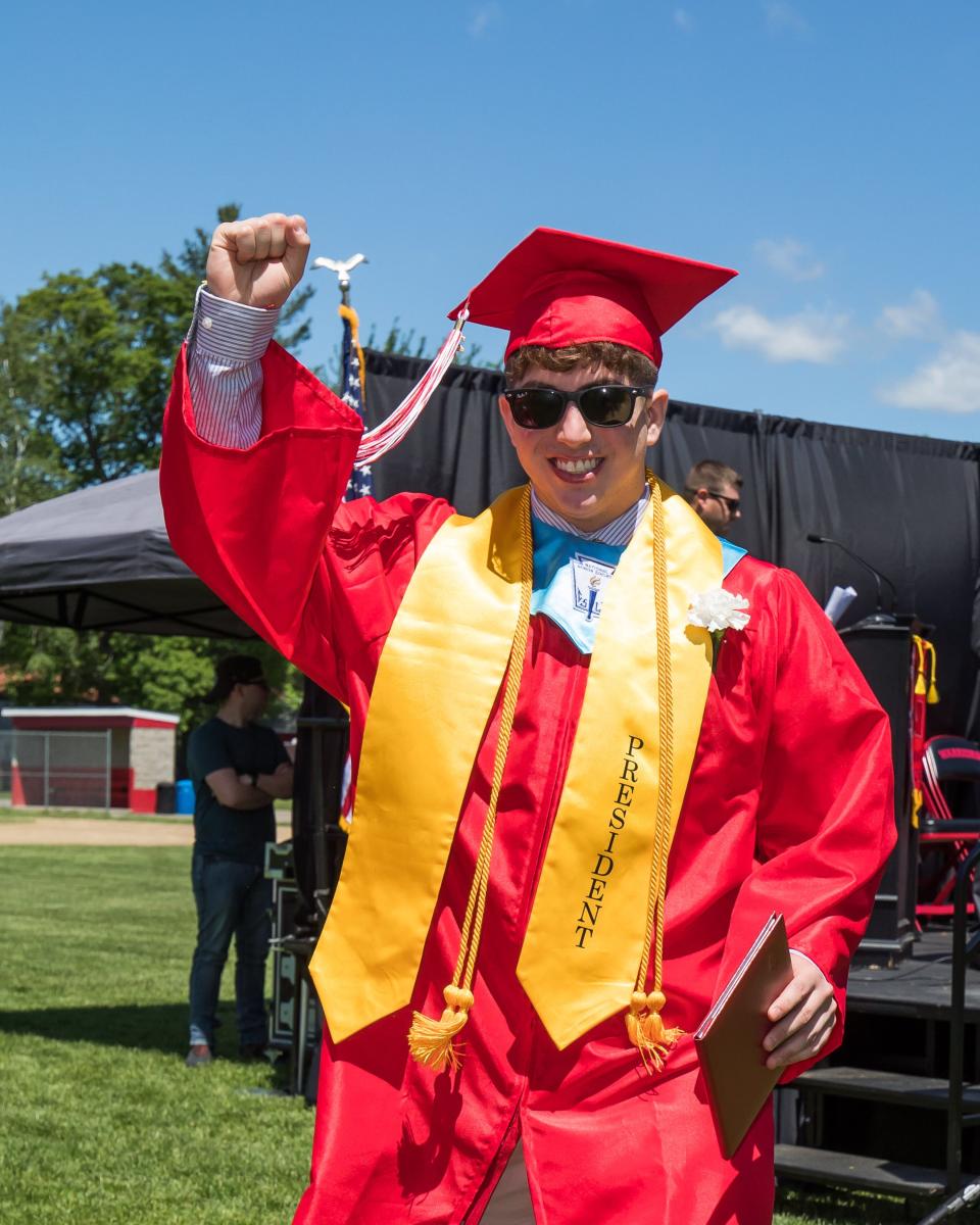 Class President Nathan Coleman raises his hand in celebration after receiving his diploma on Sunday. at  Wells High School.