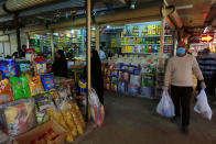 In this Tuesday, March 10, 2020 photo, people shop in the main Shurja market, in central Baghdad, Iraq. The economic fallout from the new coronavirus coupled with a sudden drop in oil prices threatens to catapult Iraq into an unprecedented crisis. The crude-exporting country is struggling to finance measures to contain the COVID-19 pandemic amid a leadership void in the federal government. (AP Photo/Hadi Mizban)