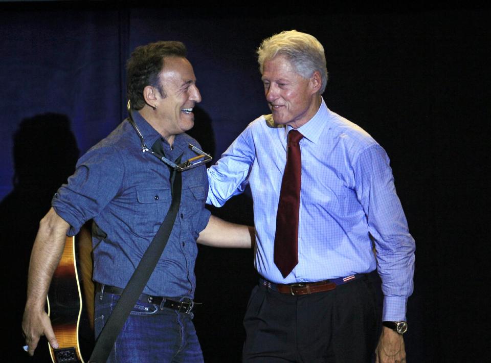 Former President Bill Clinton greets singer/songwriter Bruce Springsteen at a campaign event for President Barack Obama, Thursday, Oct. 18, 2012, in Parma, Ohio. (AP Photo/Tony Dejak)