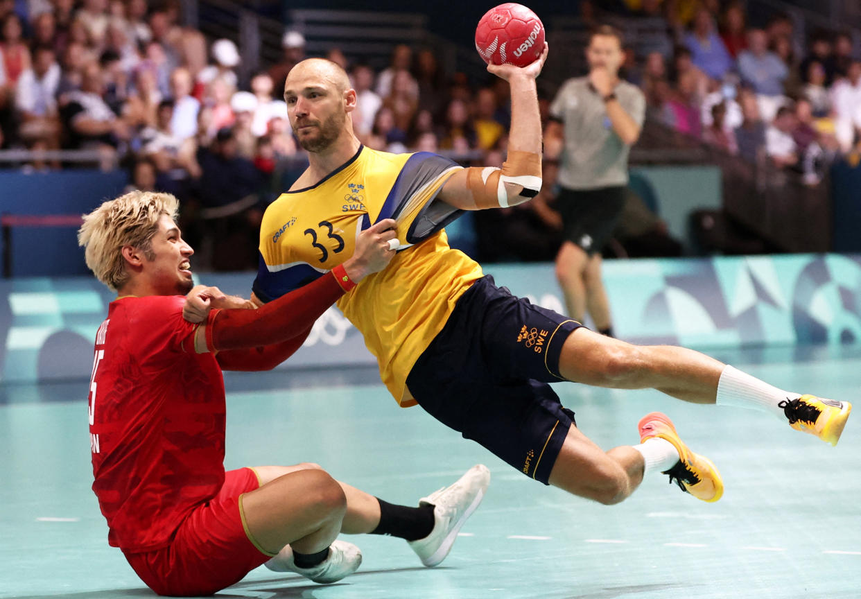 Lukas Sandell of Sweden competes against Adam Yuki Baig of Japan during the men's handball match on Sunday.