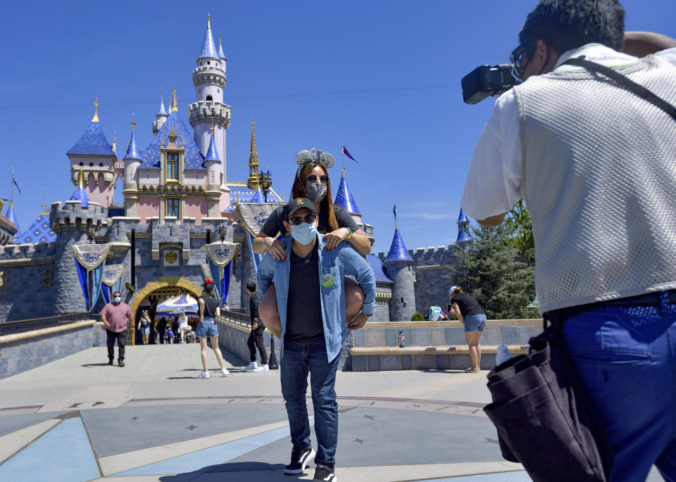 Anaheim, CA - April 30: Alexis Rangel holds his wife, Carla Rangel in front of Sleeping Beauty Castle at Disneyland as they pose for a picture in Anaheim, CA, on Friday, April 30, 2021. The resort