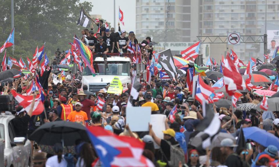 A truck carrying the singer Ricky Martin and rappers Residente and Bad Bunny joins with thousands of other people as they fill the Expreso Las Américas highway.