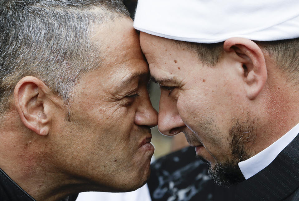 Imam of the Al Noor mosque Gamal Fouda, right, and Tu Tangata motorcycle club president Derek Tait exchange a hongi outside the mosque in Christchurch, New Zealand, Sunday, March 15, 2020. A national memorial in New Zealand to commemorate the 51 people who were killed when a gunman attacked two mosques one year ago has been canceled due to fears over the new coronavirus. (AP Photo/Mark Baker)