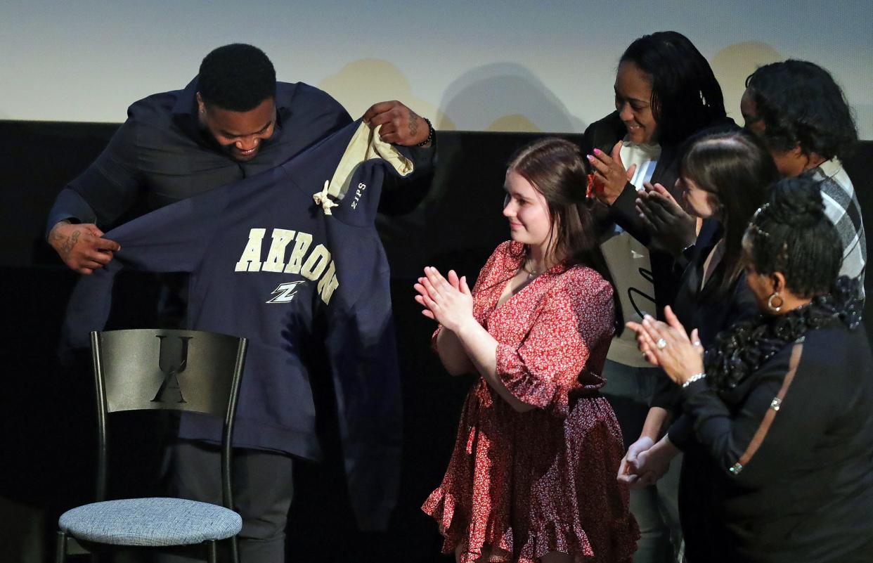 Ohio Innocence Project’s newest freed client Michael Sutton is applauded by family and friends after being presented with an Akron Zips hoodie after speaking to students at the University of Akron on Wednesday,