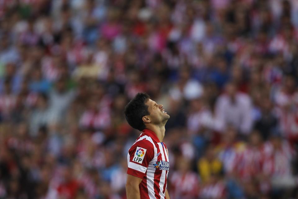 Atletico's Diego pauses, during a Spanish La Liga soccer match between Atletico Madrid and Malaga at the Vicente Calderon stadium in Madrid, Spain, Sunday May 11, 2014. (AP Photo/Gabriel Pecot)
