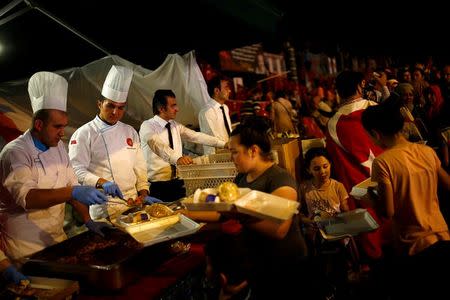 Cooks of the Presidential Palace serve food to people gathered in solidarity outside Turkish President Tayyip Erdogan's palace night after night since the July 15 coup attempt in Ankara, Turkey, July 27, 2016. REUTERS/Umit Bektas