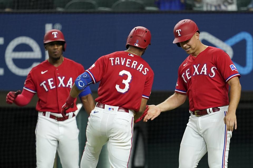 Texas Rangers' Elier Hernandez, left, Leody Taveras (3) and Nathaniel Lowe celebrate after Taveras hit a two-run home run during the seventh inning of the team's baseball game against the Seattle Mariners, Friday, July 15, 2022, in Arlington, Texas. (AP Photo/Tony Gutierrez)