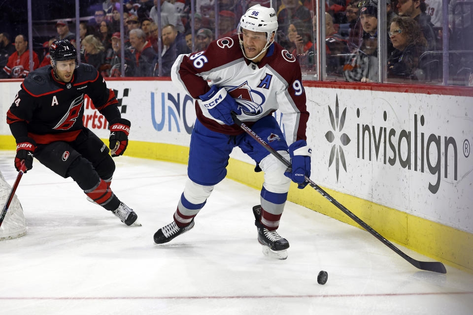 Colorado Avalanche's Mikko Rantanen (96) controls the puck in front of Carolina Hurricanes' Jaccob Slavin (74) during the first period of an NHL hockey game in Raleigh, N.C., Thursday, Feb. 8, 2024. (AP Photo/Karl B DeBlaker)