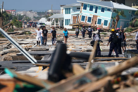 First responders and residents walk along a main street following Hurricane Michael in Mexico Beach, Florida, U.S., October 11, 2018. REUTERS/Carlo Allegri