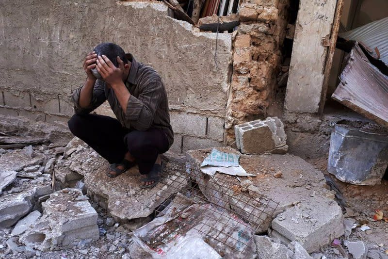 A Syrian man mourns over the bodies of children April 8, 2018, a day after an alleged chemical attack on the rebel-held town of Douma in Syria. File Photo by Mohammed Hassan/UPI