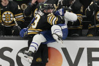 Boston Bruins left wing Brad Marchand (63) checks Toronto Maple Leafs defenseman Joel Edmundson, right, into the bench during the first period of Game 2 of an NHL hockey Stanley Cup first-round playoff series, Monday, April 22, 2024, in Boston. (AP Photo/Charles Krupa)