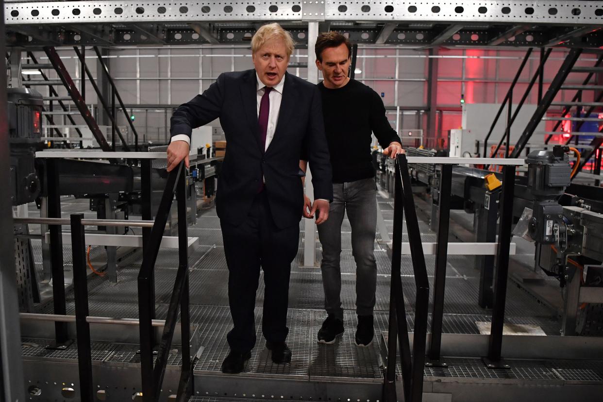 Britain's Prime Minister and Conservative party leader Boris Johnson (L) is shown around by company founder Matthew Moulding (R) during a visit to a fulfilment centre for The Hut Group (THG) in Warrington, in north-west England on December 10, 2019, as campaigning in the general election enters it's final days. - Britain will go to the polls on December 12, 2019 to vote in a pre-Christmas general election. (Photo by Ben STANSALL / POOL / AFP) (Photo by BEN STANSALL/POOL/AFP via Getty Images)